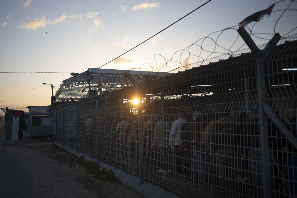 Palestinian workers line up while waiting at the Palestinian side of Erez crossing to cross into Israel, in the town of Beit Hanoun, northern Gaza Strip, March. 27, 2022. Israel said it will reopen its crossing with the Gaza Strip to Palestinian workers on Tuesday, April 26, 2022, after it had been closed for several days following rocket attacks from the Palestinian enclave. Israel has issued thousands of work permits to Palestinians from Gaza, which has been under a crippling Israeli and Egyptian blockade since Hamas seized power from rival Palestinian forces nearly 15 years ago. (AP Photo/Khalil Hamra)