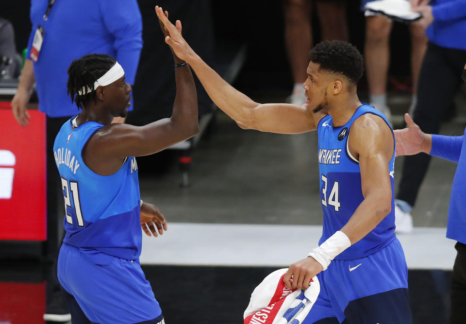 Giannis Antetokounmpo and Jrue Holiday high-five.