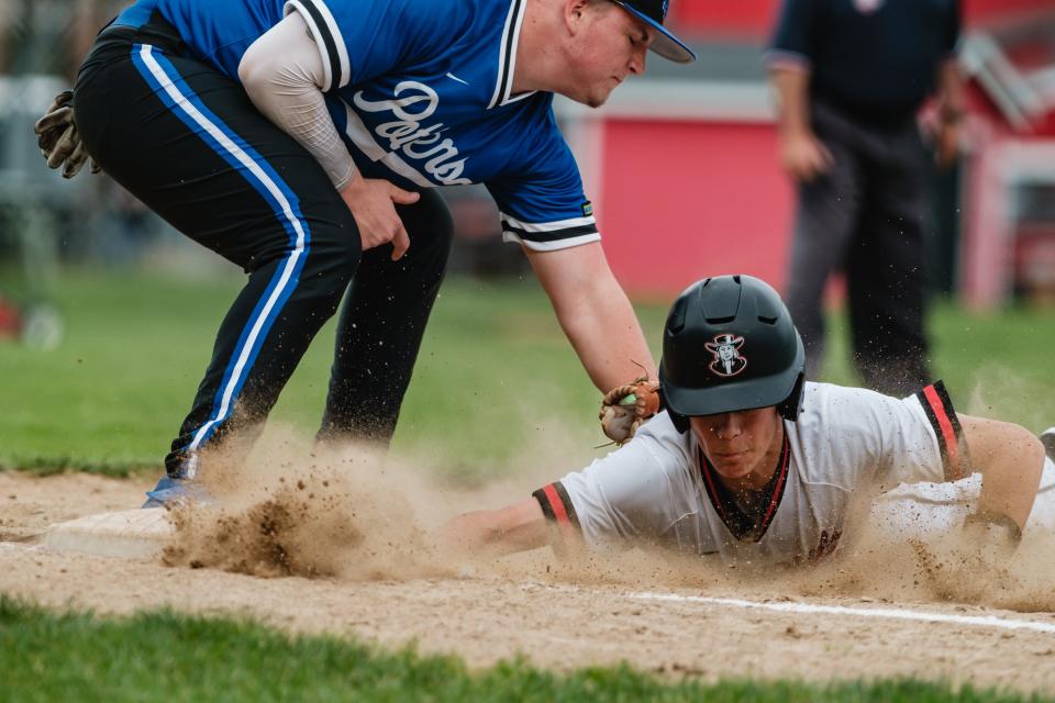 New Philadelphia's Braylon McBride slides safely back into first base during a DII East Sectional Championship game against East Liverpool, Tuesday, May 14 at Tuscora Park.