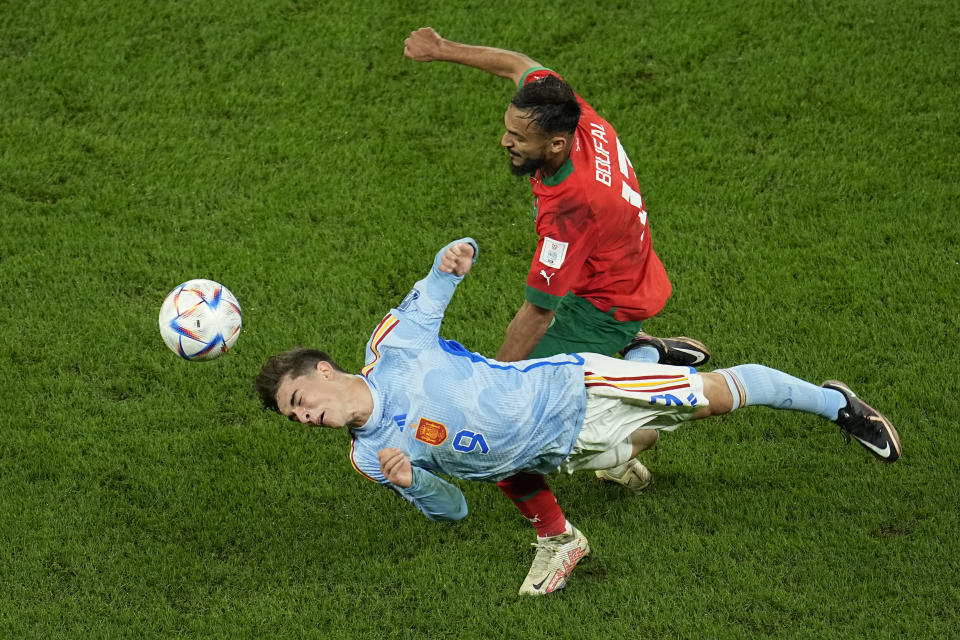 Morocco's Sofiane Boufal in action against Spain's Gavi, bottom, during the World Cup round of 16 soccer match between Morocco and Spain, at the Education City Stadium in Al Rayyan, Qatar, Tuesday, Dec. 6, 2022. (AP Photo/Abbie Parr)