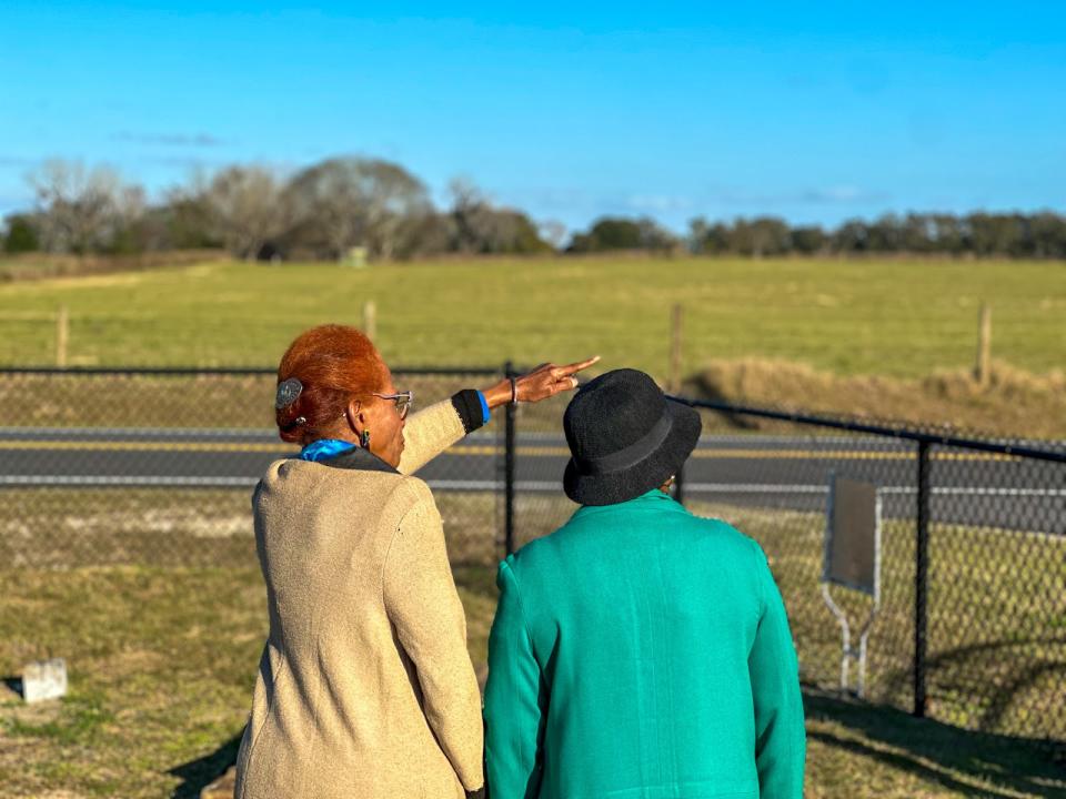 Beverly Steele (left) and resident Gwendolyn Roach look at the location where the 532-family homes will be built as they stand in the Oak Hill Cemetery in Royal, Florida. (Aallyah Wright/Capital B)