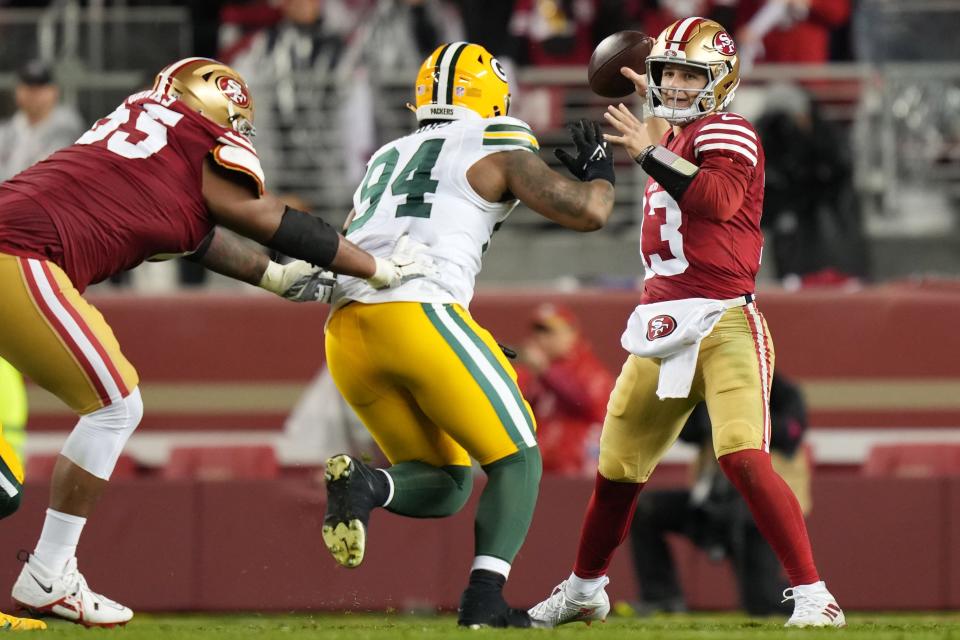 San Francisco 49ers quarterback Brock Purdy (13) passes under pressure from Green Bay Packers defensive end Karl Brooks (94) during the third quarter in a 2024 NFC divisional round game at Levi's Stadium in Santa Clara, California, on Jan. 20, 2024.