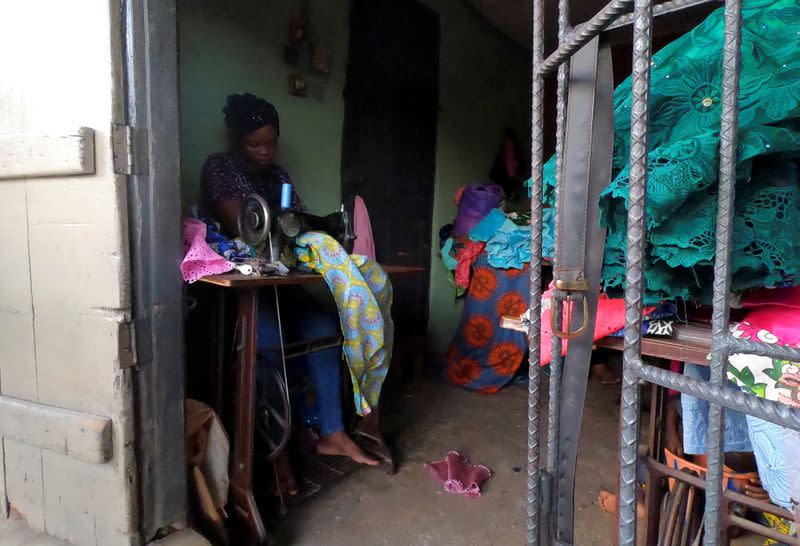 Kemi Adepoju, a dressmaker, sews a dress with a sewing machine in her shop amid the spread of the coronavirus disease (COVID-19) in Lagos