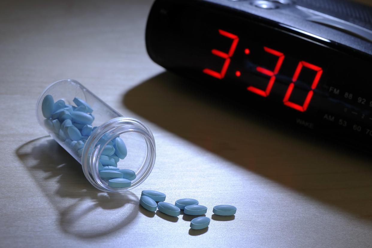 Bottle of pills next to a clock that reads 3:30 in the morning