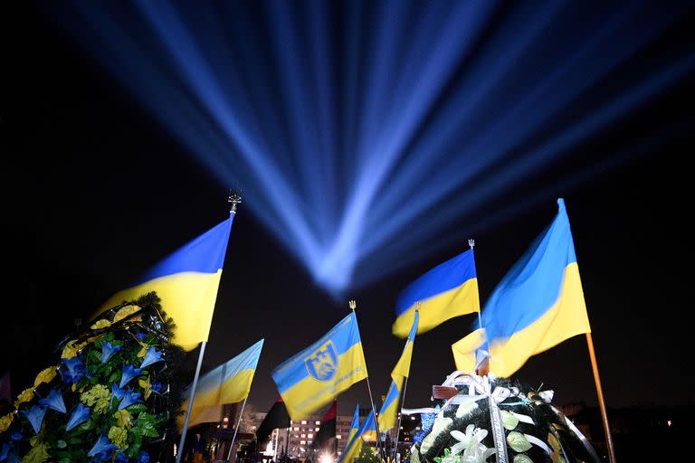 Una iluminación simbólica llamada "rayo de la memoria" se ve sobre las banderas nacionales de Ucrania y las tumbas de los soldados ucranianos que murieron en la guerra con Rusia en el cementerio de Lychakiv en Lviv el 23 de febrero de 2023.