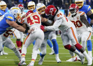 Los Angeles Chargers quarterback Justin Herbert, center, is stopped by Kansas City Chiefs safety Daniel Sorensen (49) and defensive end Melvin Ingram III during the first half of an NFL football game Thursday, Dec. 16, 2021, in Inglewood, Calif. (AP Photo/Marcio Jose Sanchez)