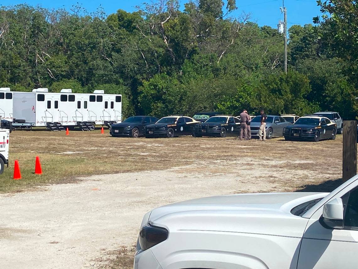 Florida Highway Patrol troopers stand by cars parked on a residential lot on Plantation Key, part of the Village of Islamorada in the Florida Keys, Thursday, Feb. 16, 2023. The cars are part of a state base camp to house police officers sent to the Keys to help with an increase in maritime migration from Cuba and Haiti, according to a statement from the Village of Islamorada.