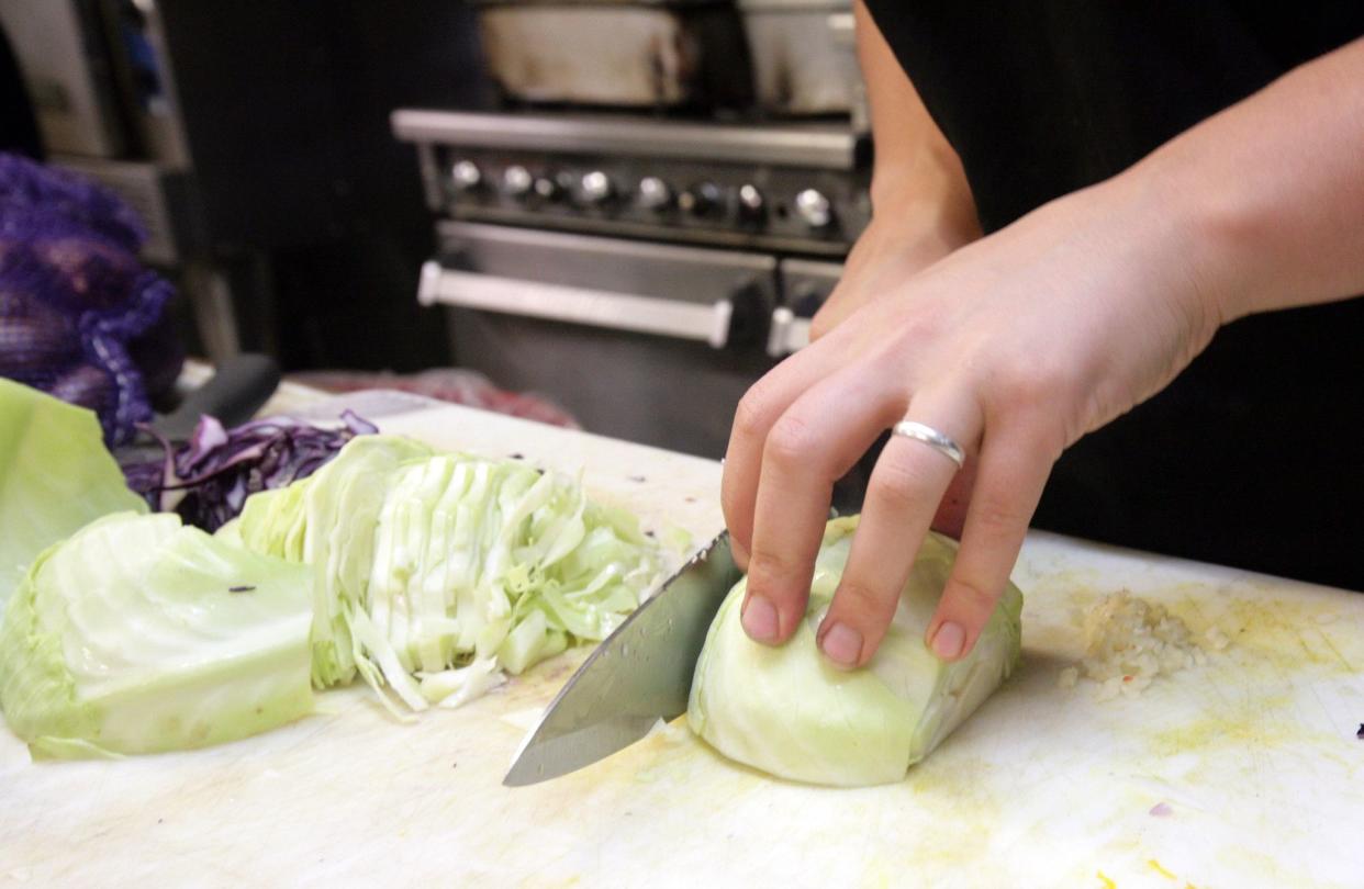 Green cabbage being sliced