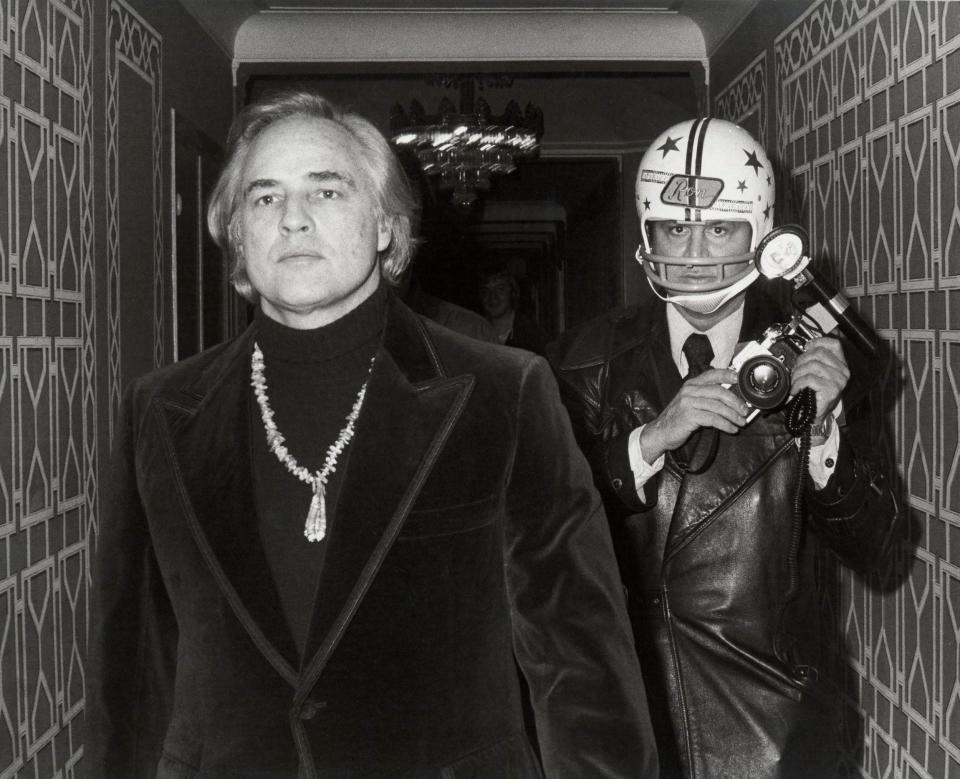 Galella with Marlon Brando, above, who punched out his teeth, after which he took to wearing an American football helmet when they met - Magnolia Pictures/Avalon
