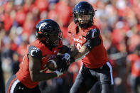 Cincinnati running back Jerome Ford, left, takes the hand off from quarterback Desmond Ridder during the first half of an NCAA college football game against UCF, Saturday, Oct. 16, 2021, in Cincinnati. (AP Photo/Aaron Doster)