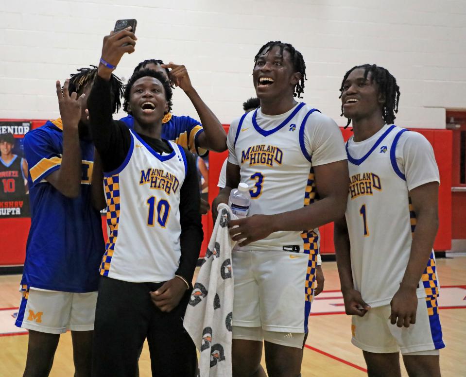 Mainland's Bubba Westbrook (10) celebrates with Narayan Thomas (3), Nathan Kirk (1) and other Bucs after the win over St. Augustine in the District 4-5A finals at Seabreeze High School on Saturday, Feb. 10, 2024.