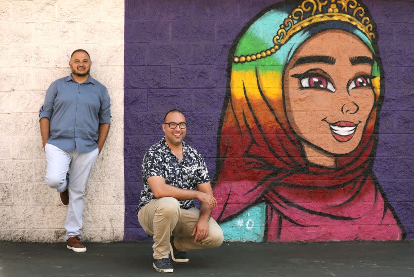 ANAHEIM, CA - AUGUST 24, 2022: Executive director of the Arab American Civic Council Rashad Al-Dabbagh, left, and research fellow Amin Nash, are photographed with a "Hijabi Queens" mural in Anaheim.The City of Anaheim has officially designated about a mile strip on Brookhurst Street as Little Arabia. (Christina House / Los Angeles Times)