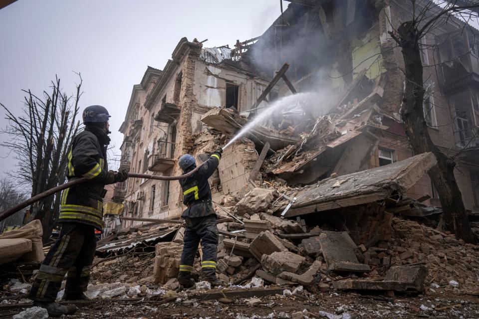 Firefighters work to extinguish a fire at the strike site (AP)