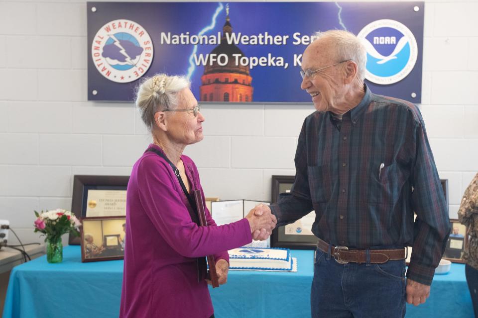 Two of the longest serving volunteer weather observers, Melba Bruce, left, of Minneapolis, and Alan Winkler, of McFarland, shake hands after being recognized for their decades of service last week at the Topeka station. Bruce has volunteered for 40 years and Winkler for 50.