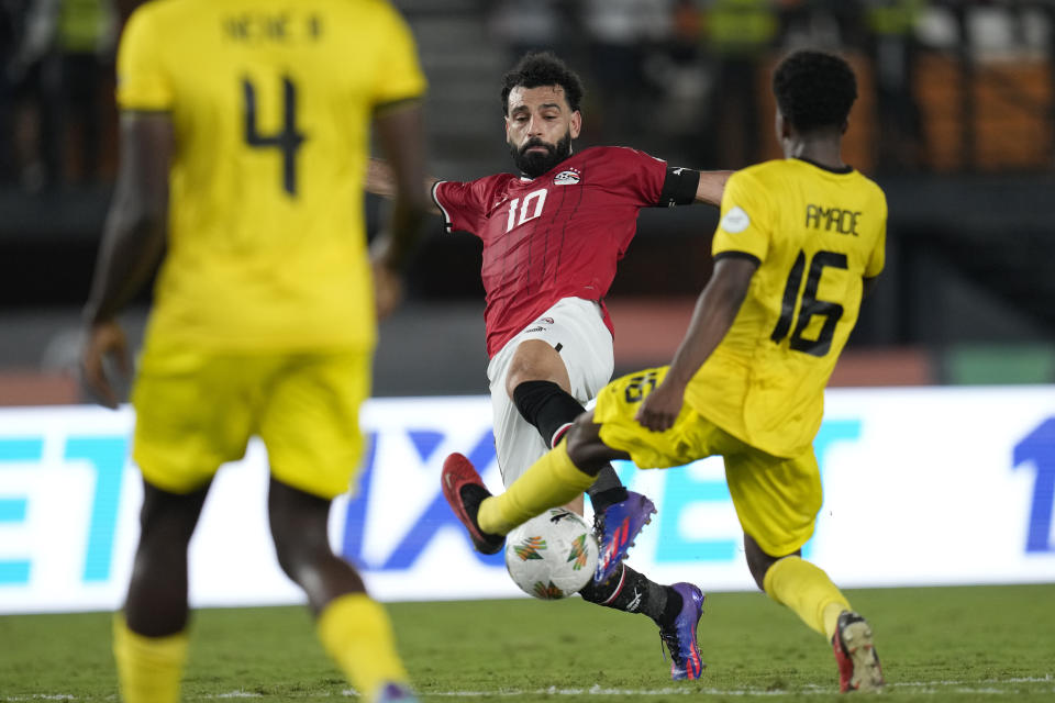 Mozambique's Alfons Amade, right goes to tackle Egypt's Mohamed Salah during the African Cup of Nations Group B soccer match between Egypt and Mozambique in Abidjan, Ivory Coast, Sunday, Jan. 14, 2024. The match ended in a 2-2 draw. (AP Photo/Themba Hadebe).