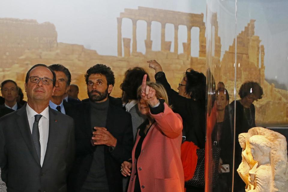 French President Francois Hollande, left, attends the opening of the Palmyra Exhibit, a three-dimensional projection featuring never-before-seen images of Palmyra taken by a drone in April after the city was liberated from IS fighters, at Grand Palais in Paris, Tuesday, Dec.13, 2016. As Islamic State extremists recapture the ancient Syrian city of Palmyra, the French president and the UNESCO chief are inaugurating an exhibit in Paris to educate the public about the wonders of endangered UNESCO heritage sites in Palmyra and the Middle East. (AP Photo/Francois Mori, Pool)