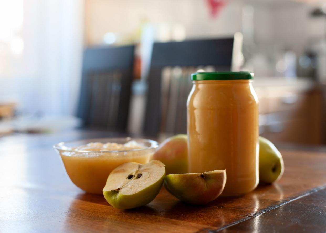 Homemade apple sauce in a glass jar on kitchen table