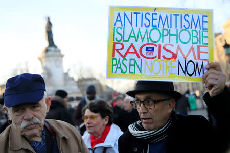 People attend a national gathering to protest antisemitism and the rise of anti-Semitic attacks in the Place de la Republique in Paris, France, February 19, 2019. The writing on the sign reads: "Antisemitism, islamophobia, racism - not in our name". REUTERS/Gonzalo Fuentes