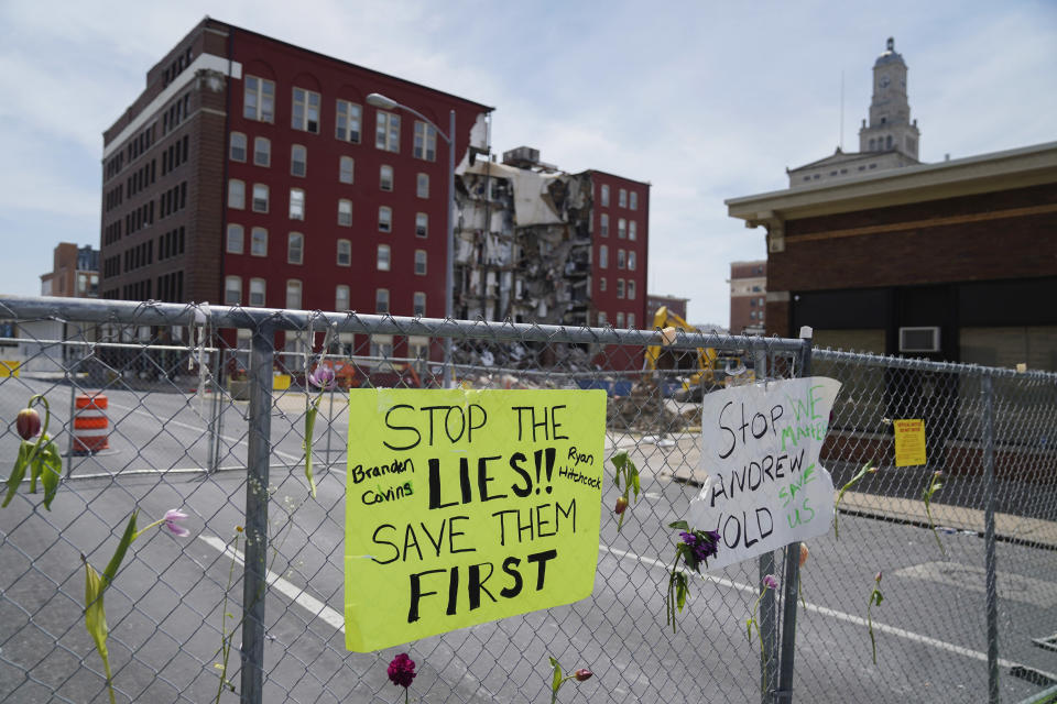 Flowers and signs are posted at the where on Sunday an apartment building partially collapsed in Davenport, Iowa, Wednesday, May 31, 2023. Five residents of a six-story apartment building that partially collapsed in eastern Iowa remained unaccounted for Tuesday, and authorities feared at least two of them might be stuck inside rubble that was too dangerous to search. (AP Photo/Erin Hooley)