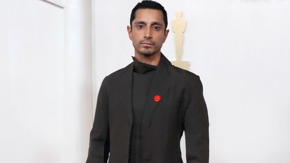 Riz Ahmed arrived in a black ensemble by Marni featuring a knee-length coat. - Jordan Strauss/Invision/AP