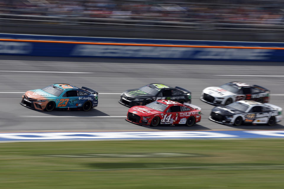 Bubba Wallace (23) leads a pack of cars during a NASCAR Cup Series auto race at Talladega Superspeedway, Sunday, April 23, 2023, in Talladega. (AP Photo/Butch Dill)