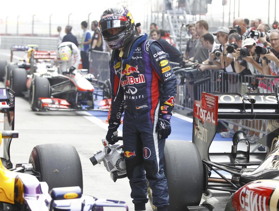 Red Bull Formula One driver Sebastian Vettel of Germany uses a fan after the qualifying session of the Indian F1 Grand Prix at the Buddh International Circuit in Greater Noida, on the outskirts of New Delhi, October 26, 2013. REUTERS/Adnan Abidi (INDIA - Tags: SPORT MOTORSPORT F1)