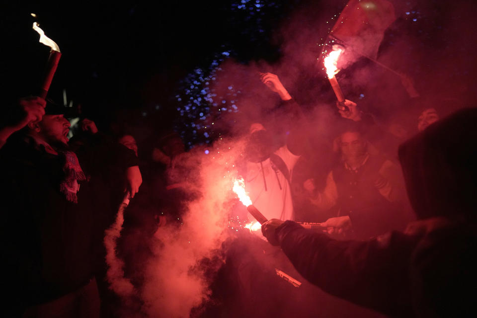 Supporters of France celebrate with flares next to the Arc de Triomphe and the Champs Elysees avenue at the end of the World Cup semifinal soccer match between France and Morocco, in Paris, Wednesday, Dec. 14, 2022. (AP Photo/Thibault Camus)