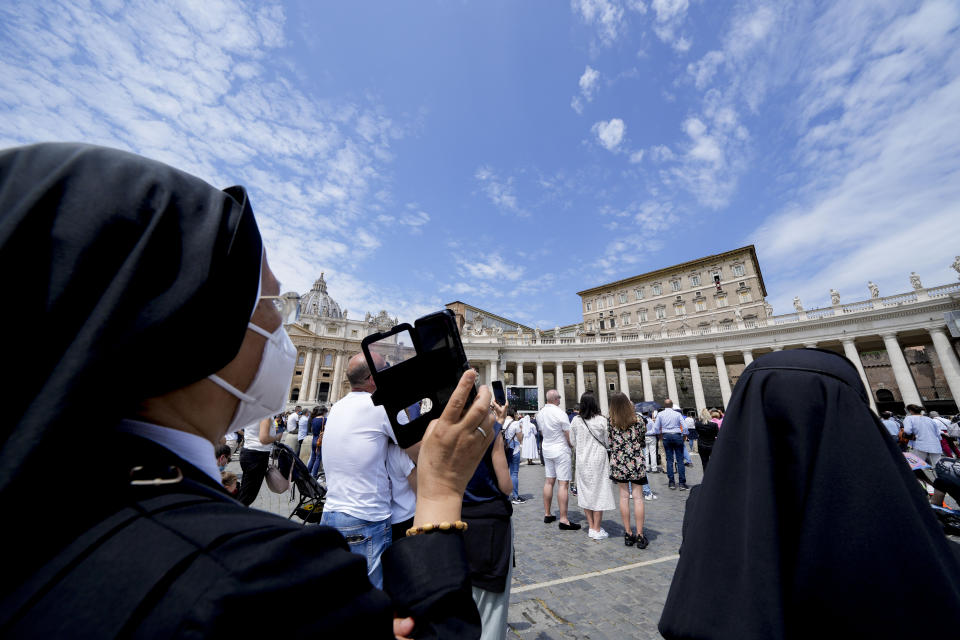 A nun takes pictures as Pope Francis recites the Angelus noon prayer from the window of his studio overlooking St.Peter's Square, at the Vatican, Sunday, May 30, 2021. (AP Photo/Andrew Medichini)
