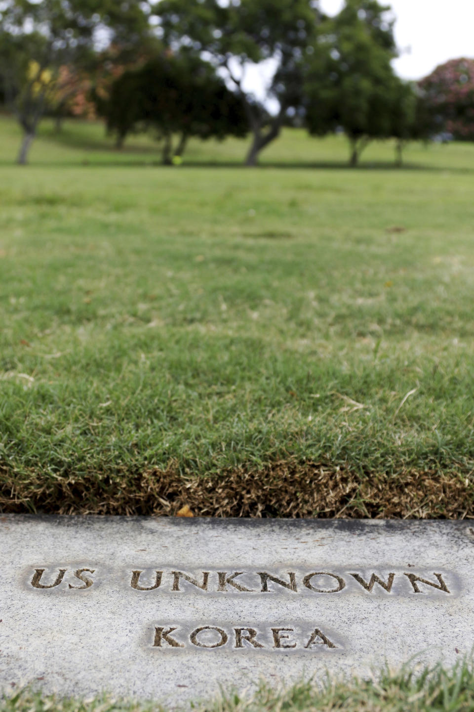 A grave marker for an unknown soldier from the Korean War is shown at the National Memorial Cemetery of the Pacific in Honolulu on Monday, July 30, 2018. Human remains handed over to the U.S. government from North Korea are expected to arrive Wednesday in Honolulu, where scientists will begin the painstaking process of trying to match DNA from the bones to those of American soldiers who didn't return from the Korean War more than a half century ago. (AP Photo/Caleb Jones)