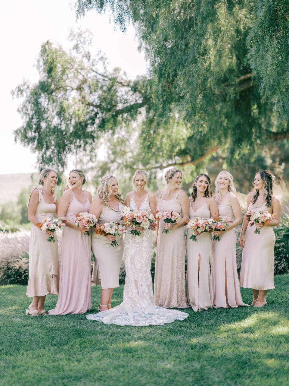 bridesmaids posing under tree