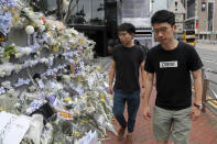 Pro-democracy activist Joshua Wong, left, is accompanied by Nathan Law as they arrive at a makeshift memorial to a pay respect to a protester who fell to his death after hanging a protest banner against an extradition bill in Hong Kong, Monday, June 17, 2019. Wong, a leading figure in Hong Kong's 2014 Umbrella Movement demonstrations, was released from prison on Monday and vowed to soon join the latest round of protests. (AP Photo/Kin Cheung)