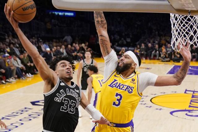 San Antonio Spurs guard Tre Jones, left, shoots as Los Angeles Lakers forward Anthony Davis defends during the first half of an NBA basketball game Wednesday, Jan. 25, 2023, in Los Angeles. (AP Photo/Mark J. Terrill)