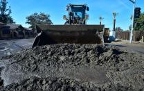 <p>A constrution vehicle clears mud along La Tuna Canyon Road in Sun Valley neighborhood of Los Angeles, Calif., on Jan. 10, 2018. (Photo: Frederic J. Brown/AFP/Getty Images) </p>