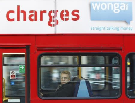 A passenger sits on a bus beneath an advert for short term loan company Wonga in London December 18, 2012. REUTERS/Luke MacGregor