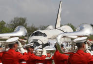 A military band plays as the the Space Shuttle Discovery is towed up to an event at the Smithsonian National Air and Space Museum Steven F. Udvar-Hazy Center April 19, 2012 in Chantilly, Virginia. The space shuttle Discovery is the he oldest and most traveled vehicle from NASA's space shuttle program, and will replace the Interprise at the museum. (Photo by Mark Wilson/Getty Images)