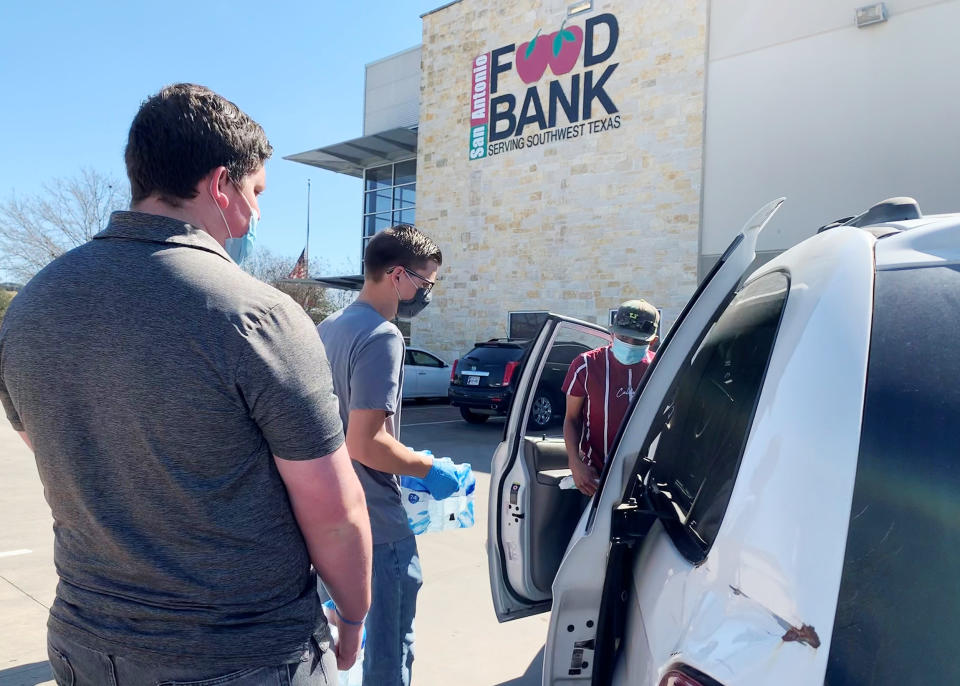 Michael Ybarra, right, had tried to get groceries during the storm but his car broke down. He was picking up water being distributed by the San Antonio food bank. (Suzanne Gamboa / NBC News)