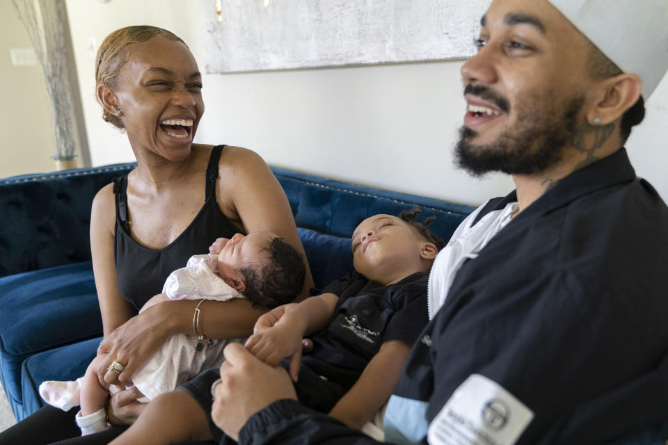 Aaliyah Wright, 25, of Washington, holds their newborn daughter Kali, as her husband Kainan Wright, 24, of Washington, holds their son Khaza, 1, during a visit to the children's grandmother in Accokeek, Md., Tuesday, Aug. 9, 2022. A landmark social program is being pioneered in the nation’s capital. Coined “Baby Bonds,” the program is designed to narrow the wealth gap. The program would provide children of the city’s poorest families up to $25,000 when they reach adulthood. (AP Photo/Jacquelyn Martin)