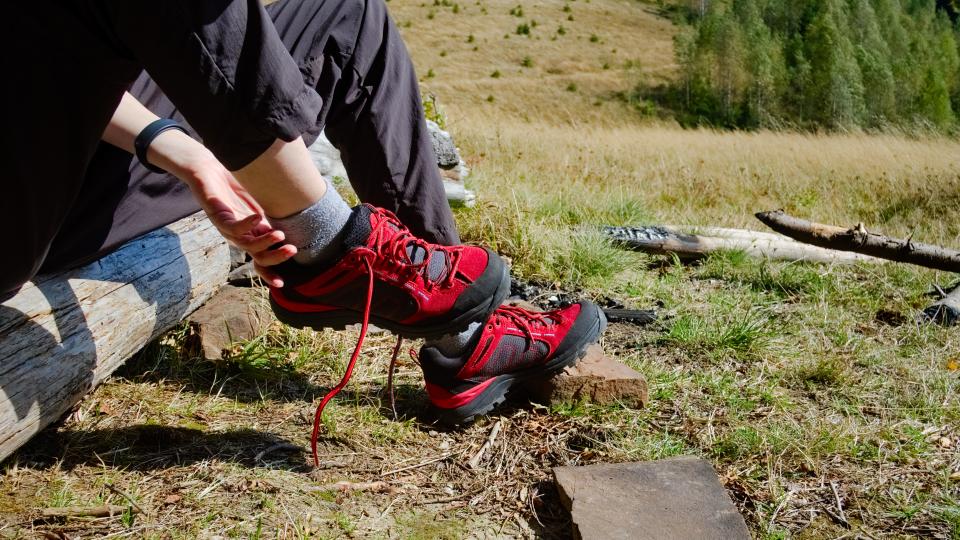 Girl taking off shoes on hiking trail