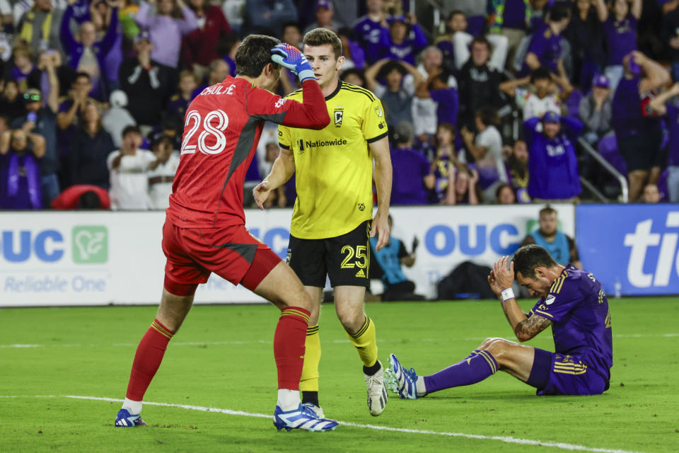 Orlando City defender Kyle Smith, right, reacts after miss a goal attempted and Columbus Crew goalkeeper Patrick Schulte (28) talks to team mate midfielder Sean Zawadzki (25) during ver time of an MLS soccer playoff match, Saturday, Nov. 25, 2023, in Orlando, Fla. (AP Photo/Kevin Kolczynski)