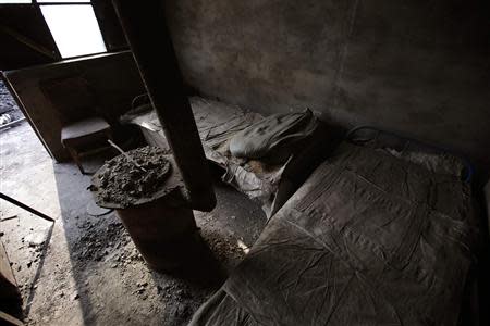 A deserted house with beds and a hearth is pictured inside an abandoned steel mill of Qingquan Steel Group in Qianying township, Hebei province February 18, 2014. REUTERS/Petar Kujundzic