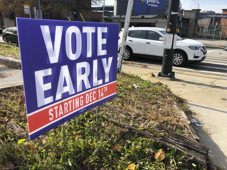 FILE - In this Dec. 11, 2020 file photo, a sign in an Atlanta neighborhood urges people to vote early in Georgia's two U.S. Senate races. Republicans are moving to make it harder for that to happen again, potentially affecting the voting preferences for millions of Americans in future elections. The GOP's campaign to place new restrictions on mail-in and early voting in certain states will force voters to contend with new rules on what are popular and proven methods of casting ballots. (AP Photo/Jeff Amy, File)