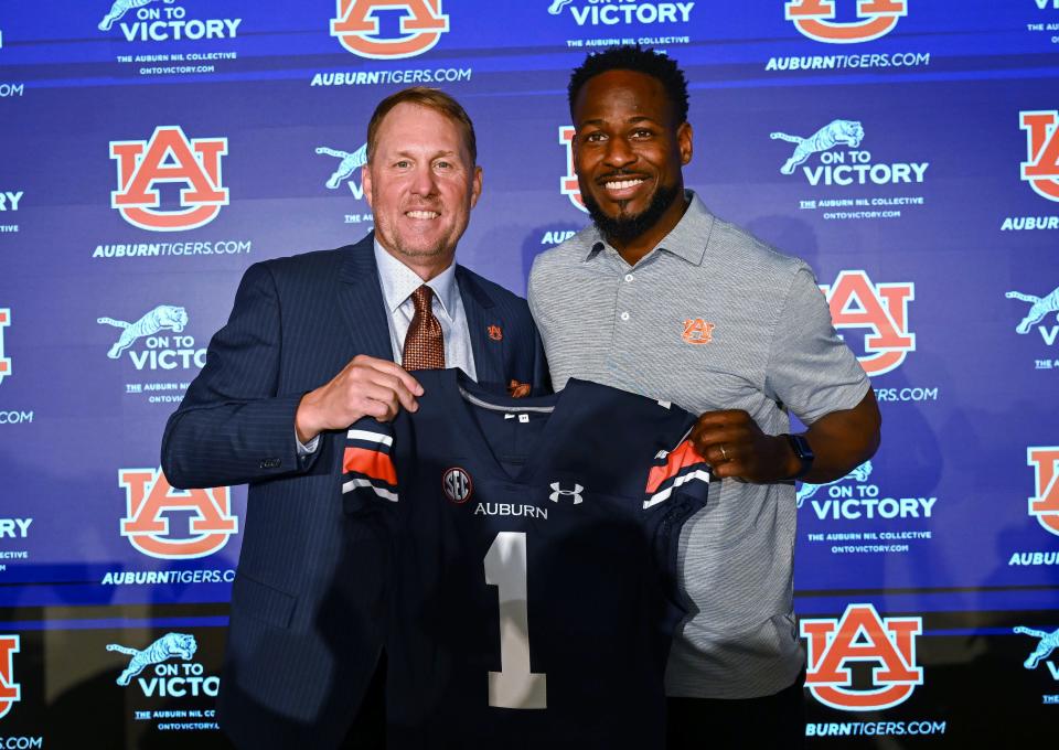 Newly named Auburn football coach Hugh Freeze, left, and Carnell Williams, who will stay on as running backs coach and associate head coach, pose for photos at a news conference Tuesday, Nov. 29, 2022, in Auburn, Ala. (AP Photo/Todd Van Emst)