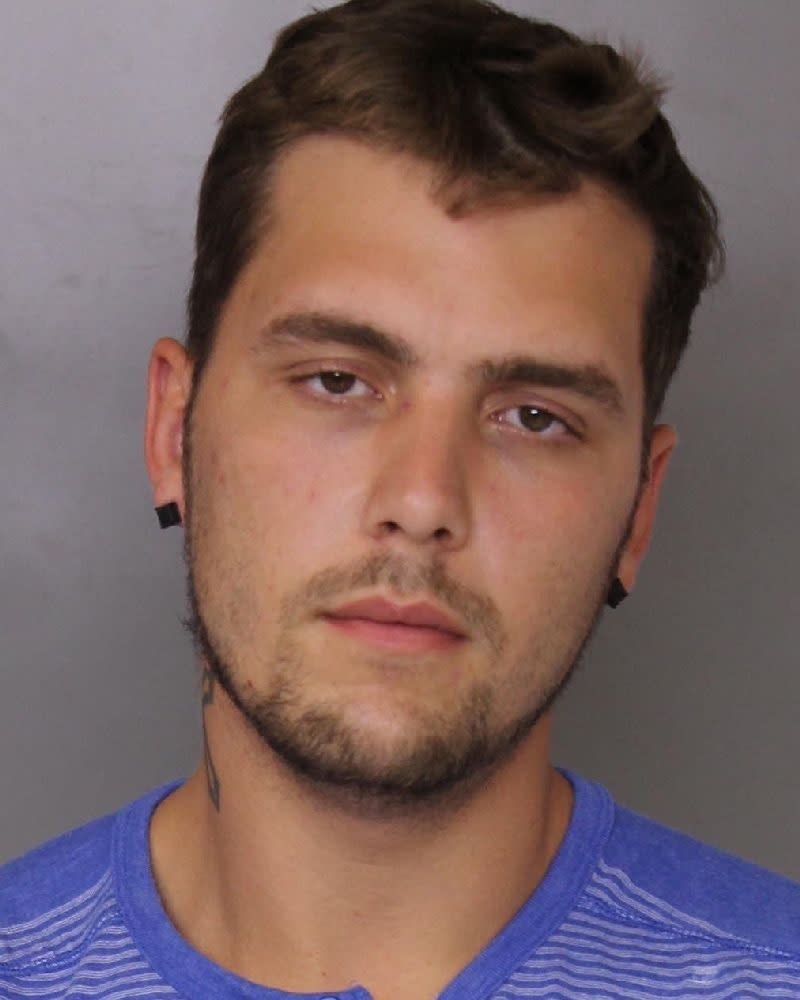 This booking photo provided by Baltimore County police shows Jacob William Rogge. Baltimore County police have captured Rogge, suspected of robbing a convenience store on Saturday, March 17, 2019 dressed in a unicorn costume. Rogge donned a pink-and-white unicorn costume and smashed a High's Dairy Store register with a crowbar. Police say 27-year-old Joseph Philip Svezzese drove Rogge, who fled with cash and cigarettes.(Baltimore County police via AP)