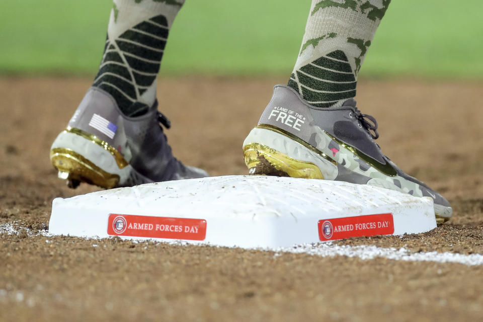 Philadelphia Phillies' Rhys Hoskins stands on first base Friday, May 14, 2021, while wearing cleats in honor of Armed Forces Day, which is Saturday, during the fourth inning of the team's baseball game against the Toronto Blue Jays in Dunedin, Fla. (AP Photo/Mike Carlson)