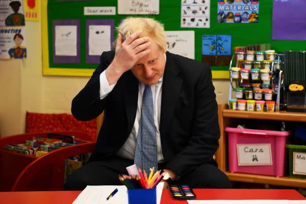 UK prime minister Boris Johnson reacts as he prepares to paint with children during a visit at the Field End Infant school on May 6, 2022. (Photo: WPA Pool via Getty Images)