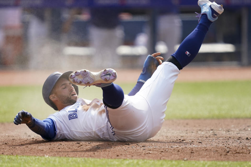 Toronto Blue Jays' George Springer (4) reacts after sliding into home plate during the fifth inning of a baseball game against the Minnesota Twins in Toronto, Saturday, June 10, 2023. (Arlyn McAdorey/The Canadian Press via AP)
