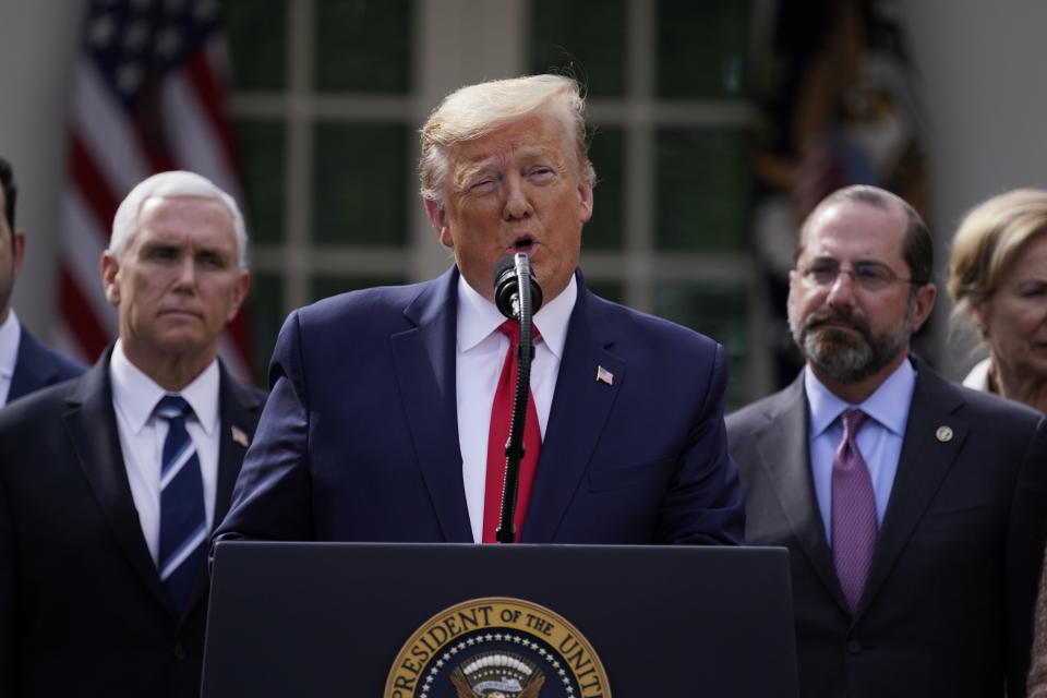 President Donald Trump speaks during a news conference about the coronavirus in the Rose Garden of the White House, Friday, March 13, 2020, in Washington. Department of Health and Human Services Secretary Alex Azar, right, and Vice President Mike Pence listen. (AP Photo/Evan Vucci)