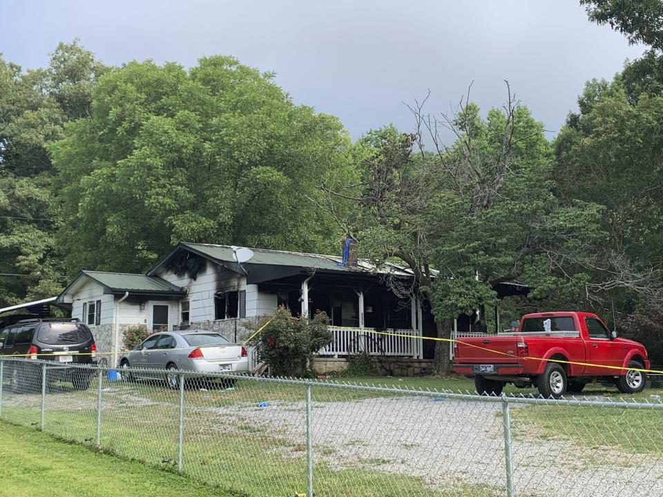 Police tape blocks off a home in Sequatchie, Tenn., Friday, June 16, 2023. Six people including three children were found dead in the Tennessee home where police responded to a shooting and arrived to find the residence ablaze, Thursday night June 15, authorities said. (Ellen Gerst/Chattanooga Times Free Press via AP)