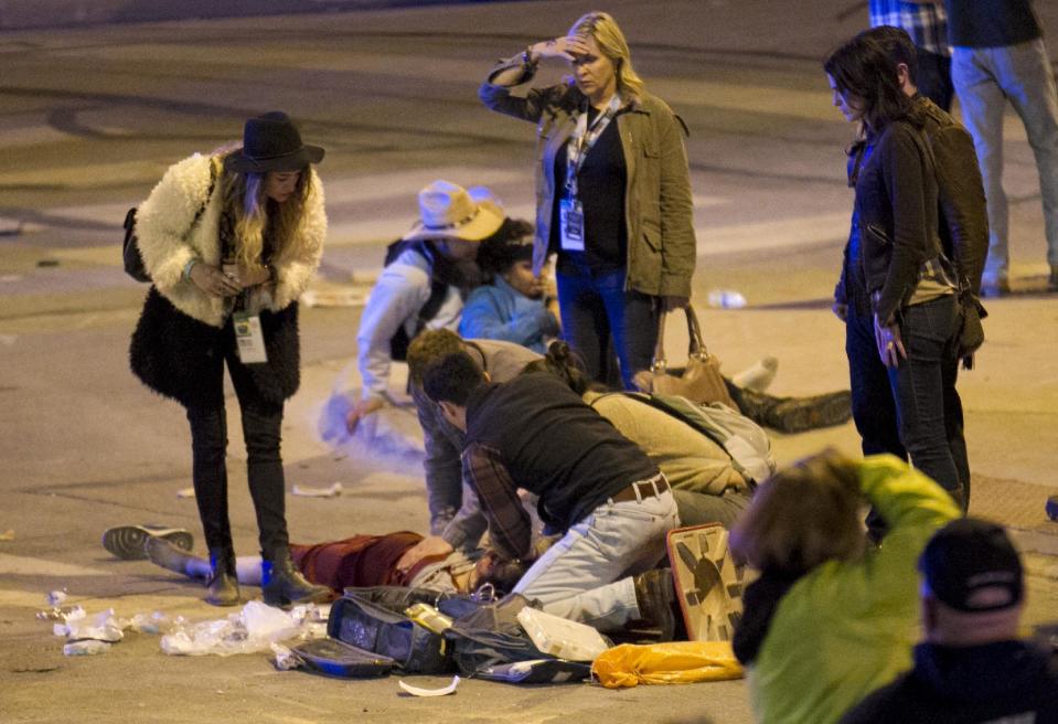 People perform CPR on a woman after she was struck by a vehicle on Red River Street in downtown Austin, Texas, at SXSW on Wednesday March 12, 2014. Her condition is unknown. Police say two people have died after a car drove through temporary barricades set up for the South By Southwest festival and struck a crowd of pedestrians. (AP Photo/Austin American-Statesman, Jay Janner)