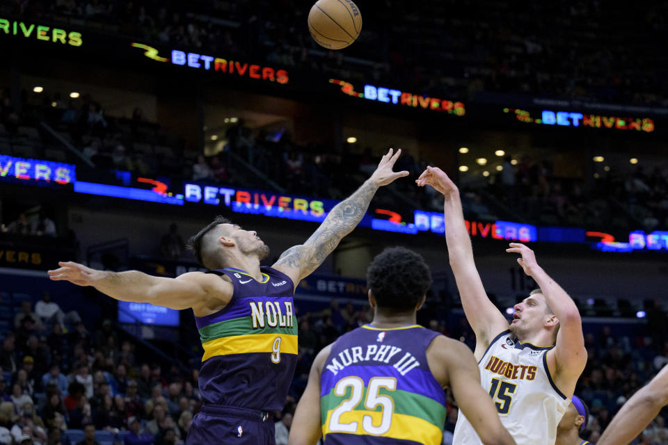 Denver Nuggets center Nikola Jokic (15) shoots over New Orleans Pelicans center Willy Hernangomez (9) in the second half of an NBA basketball game in New Orleans, Tuesday, Jan. 24, 2023. (AP Photo/Matthew Hinton)